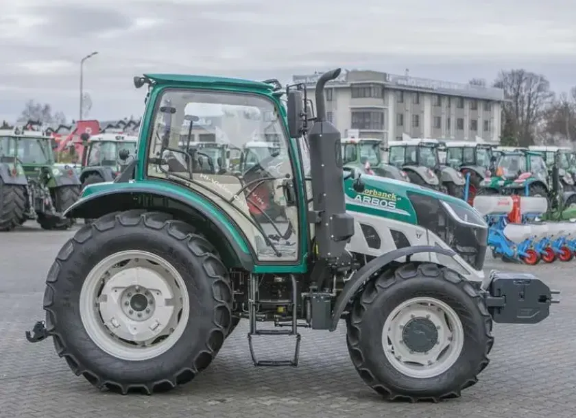 Bok ciągnika arbos 5115 advanced w tle biurowiec korbanek.pl