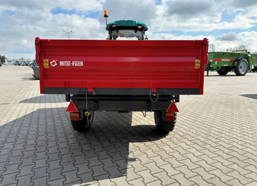 Czerwona przyczepa wywrotka T735C/1 o ładowności 3200 kg firmy Metal-Fach podczepiona do ciągnika ARBOS 3055