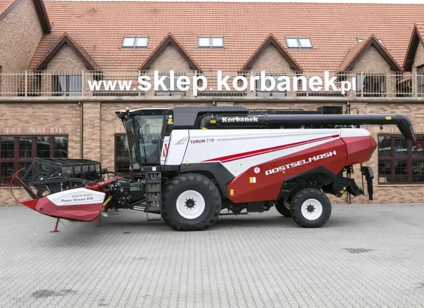 Boczny widok kombajnu Rostselmash Torum stojącego na tle sklepu korbanek.