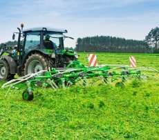 Zielony przetrząsacz zawieszany Samasz model P6 podczas pracy - przetrząsa trawę