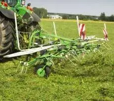 Przetrząsacz zawieszany Samasz model P4 podczas pracy na łące