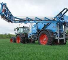 Niebieski opryskiwacz polowy zaczepiany firmy lemken typ Albatros pracujący na polu z ciągnikiem rolniczym Korbanek.pl