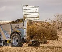 Rozrzutnik obornika Cynkomet Zeus podczas rozrzutu obornika na polu