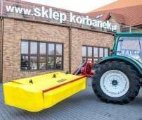 Żółto czerwona kosiarka fella prezentowana z ciągnikiem arbos serii 5000