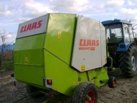 Używana Prasa zwijająca walcowa Claas Rollant 66 podczas jazdy z ciągnikiem 