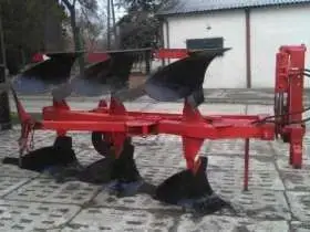 Używany Pług obracalny niemiecki BVL na utwardzonym placu w tle biały budynek