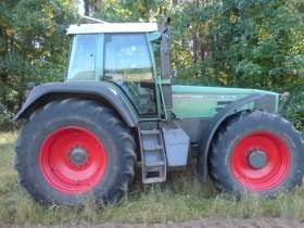 Używany ciągnik rolniczy Fendt 926 Vario widok na prawy bok na tle zarośli 
