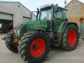 Zielony ciągnik niemieckiego producenta Fendt 714 Vario w zabudowaniach gospodarstwa 