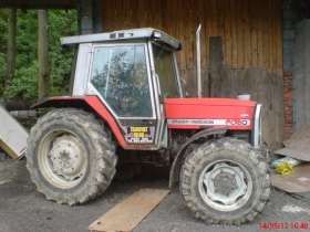 Czerwony używany ciągnik marki Massey Ferguson 3050 widok na bok 