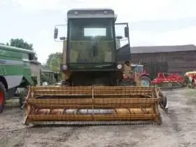 używany kombajn zbożowy Bizon Z 056 1981 r z kabiną kolor żółty z hederem