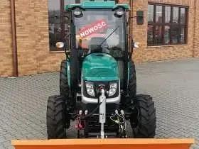 Ciągnik Arbos 2035 prezentowany od przodu z widokiem na spychacz Hydramet