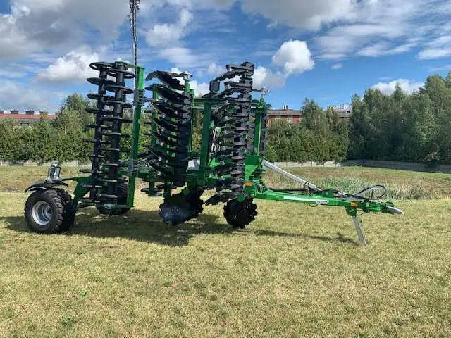 Brona talerzowa Tolmet Megatron w tle jest serwis kombajnów Korbanek maszyna widoczna od tyłu wózek maszyny 