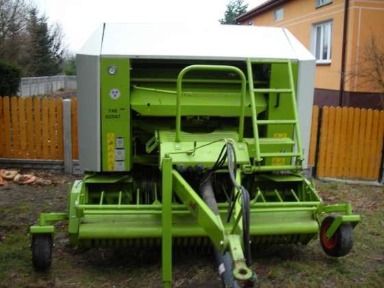 Claas Rolant 255 RC używana prasa widok z przodu w tle budynek 