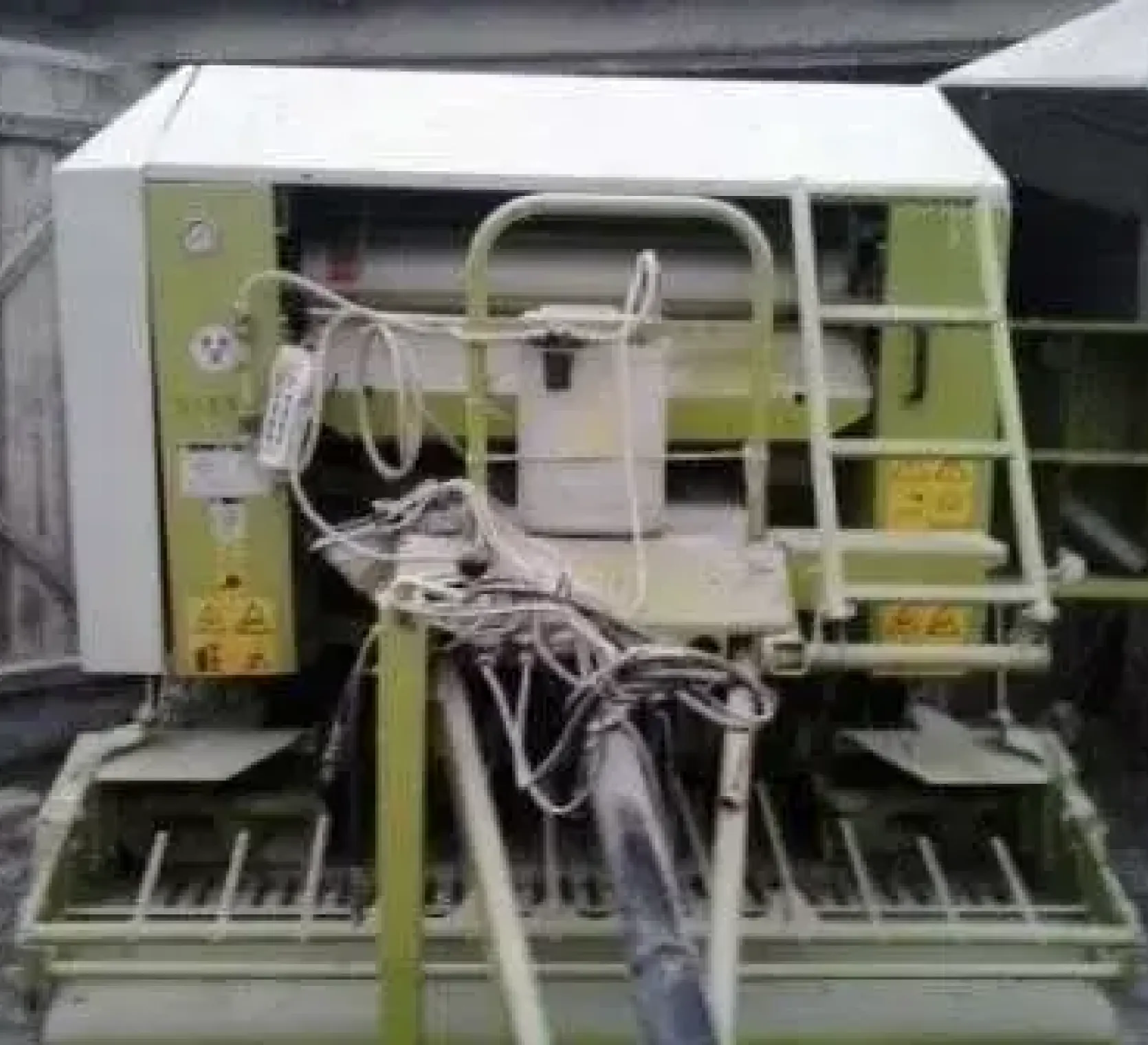 Używany Prasa Claas Rollant 255 RC  na tle otwartych drewnianych drzwi widok na dyszel 