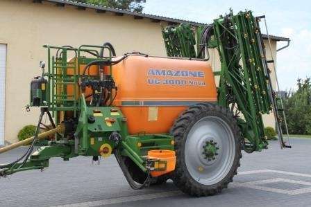 Używany Opryskiwacz Amazone UG3000 Nova, rocznik 2005 na tle budynku