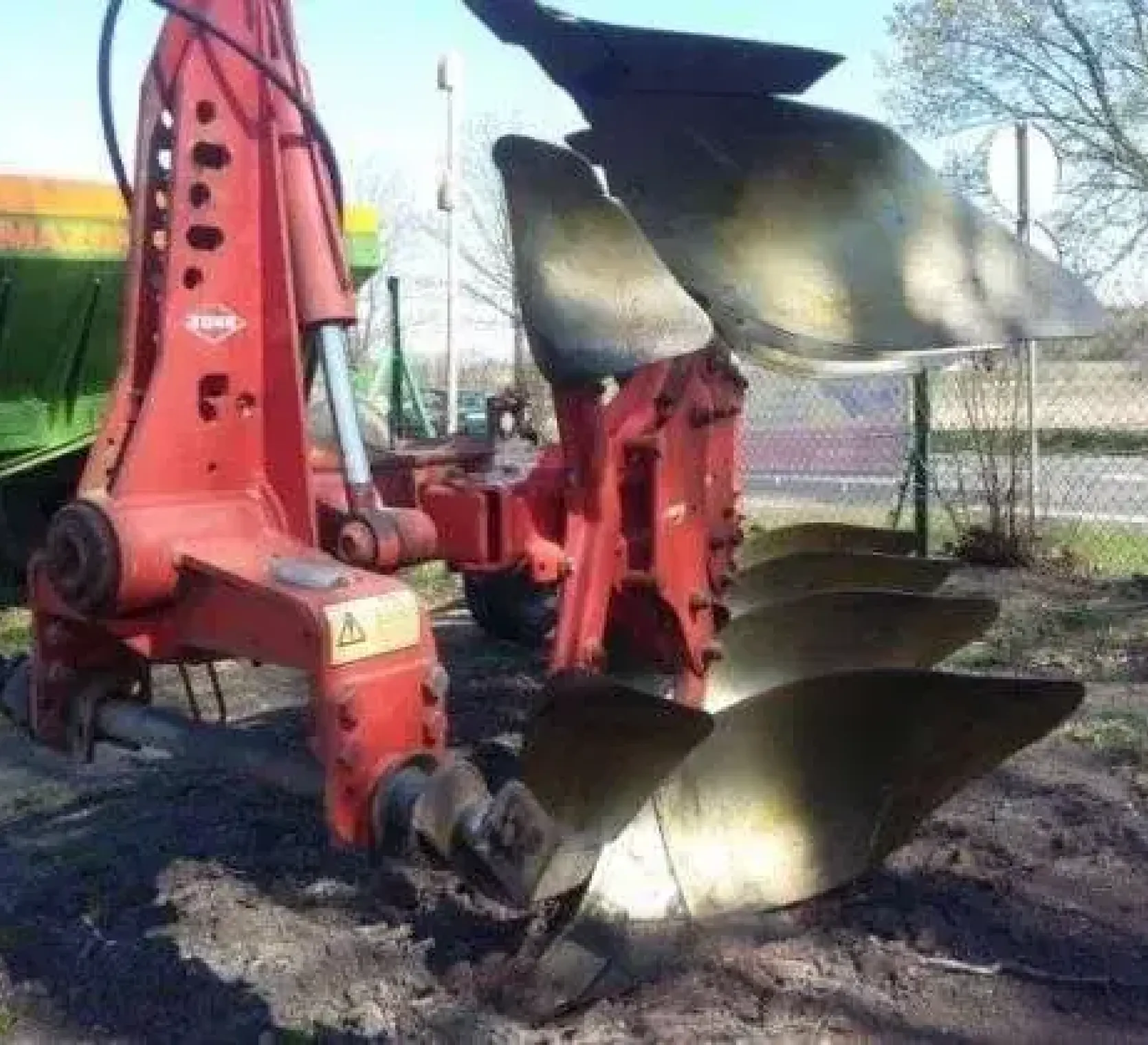 Tył używanego pługa obracalnego Kuhn Multimaster na tle rozsiewacza nawozów Amazone 