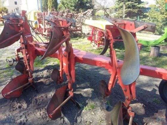 Używany pług obracany 4 skibowy, Kuhn Multimaster zaprezentowany na tle innych używanych maszyn rolniczych z gospodarstwa sprzedającego 