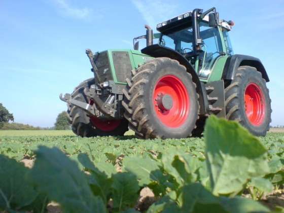 Używany zadbany ciągnik rolniczy Fendt 926 Vario jadący polną drogą 