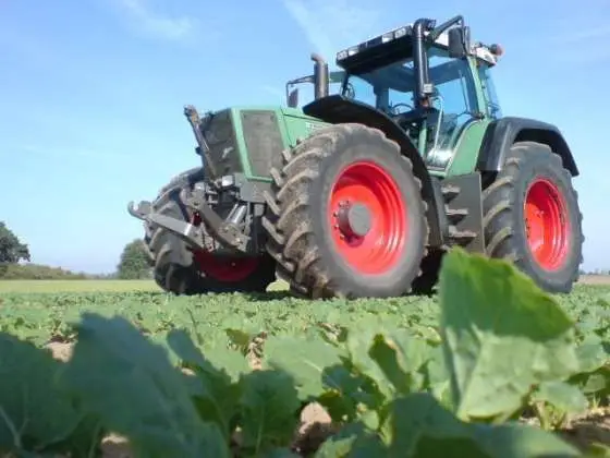 Używany zadbany ciągnik rolniczy Fendt 926 Vario jadący polną drogą 