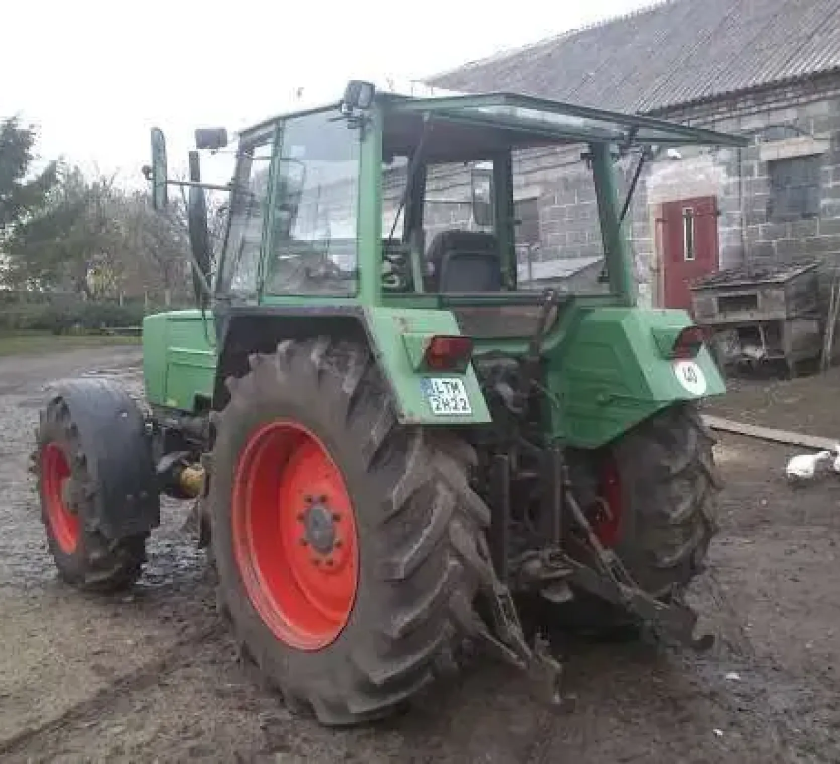 Zadbany ciągnk rolniczy Fendt 309 w zabudowaniach gospodarczych 