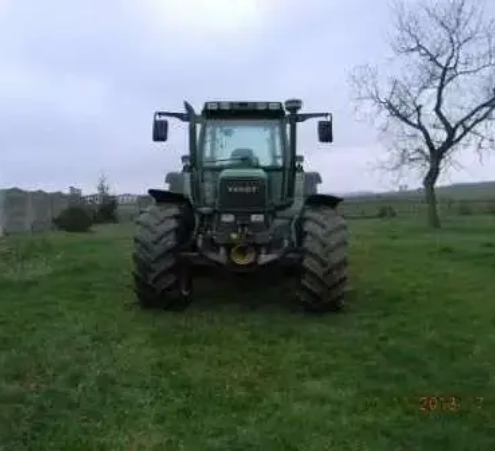 Używany ciągnik rolniczy Fendt 515 C rocznik 1997 widok na przód pojazdu stojącego na łące 