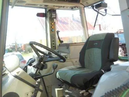 Wnętrze zadabnego używanego ciągnika rolniczy marki Fendt 515 C widok na siedzenie operatora i kierownicę 