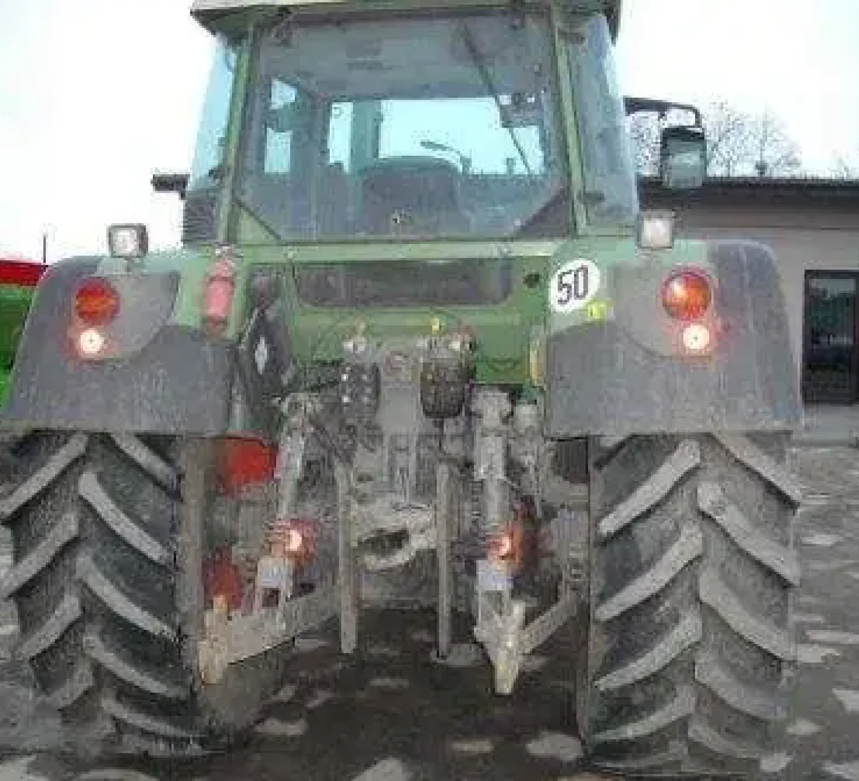 Tył używanego ciągnika rolniczego Fendt 412 Vario na drugim planie rozsiewacz nawozów Amazone  