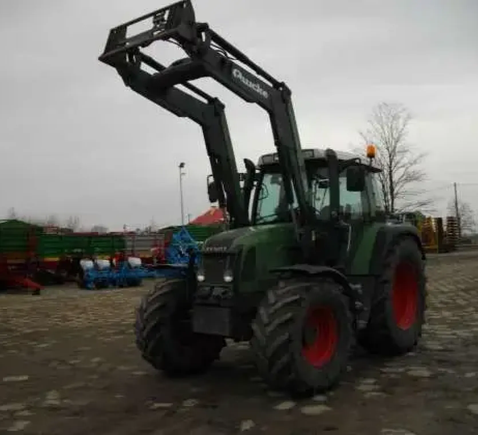 Ciągnik rolniczy Fendt 410 Vario z uniesionym ładowaczem czołowym Quicke