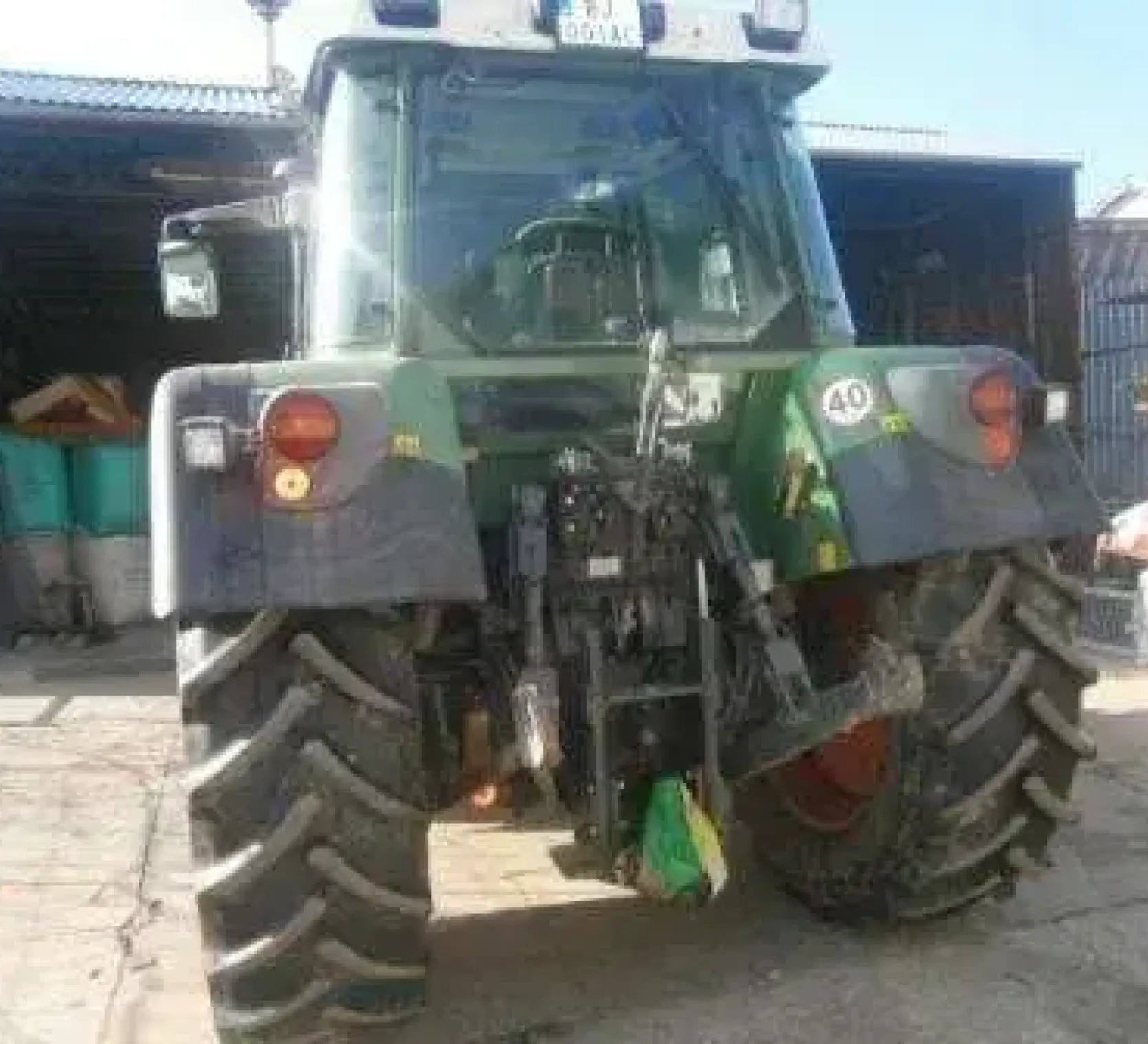 Traktor rolniczy Fendt 312 Vario - używany z 2008 roku widok na tył pojazdu na tle zabudowań gospodarczych 
