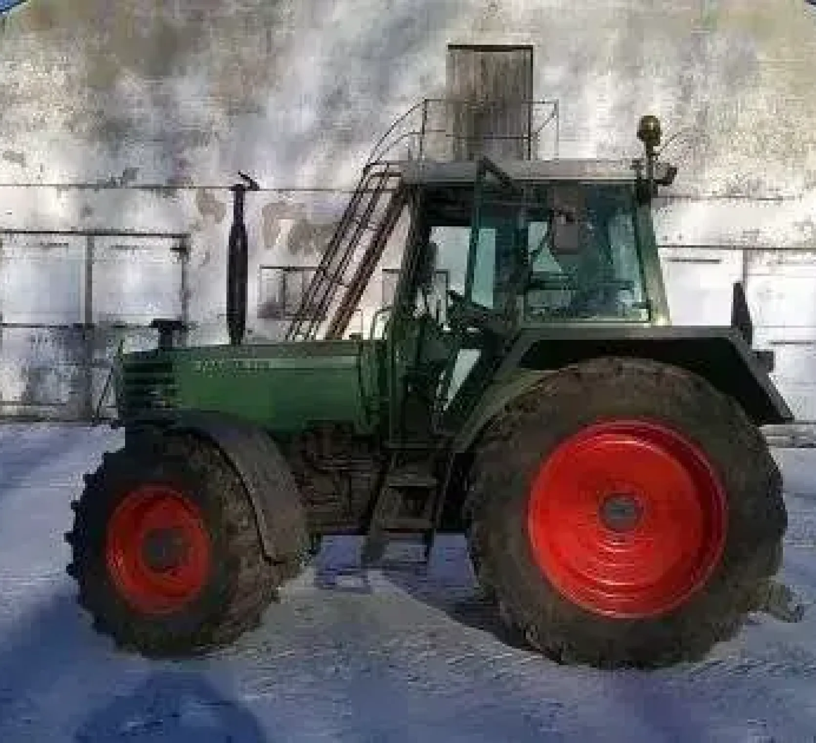 Używany ciagnik rolniczy Fendt 310 na tle zabudowań gospodrstwa widom na lewy bok pojazdu 