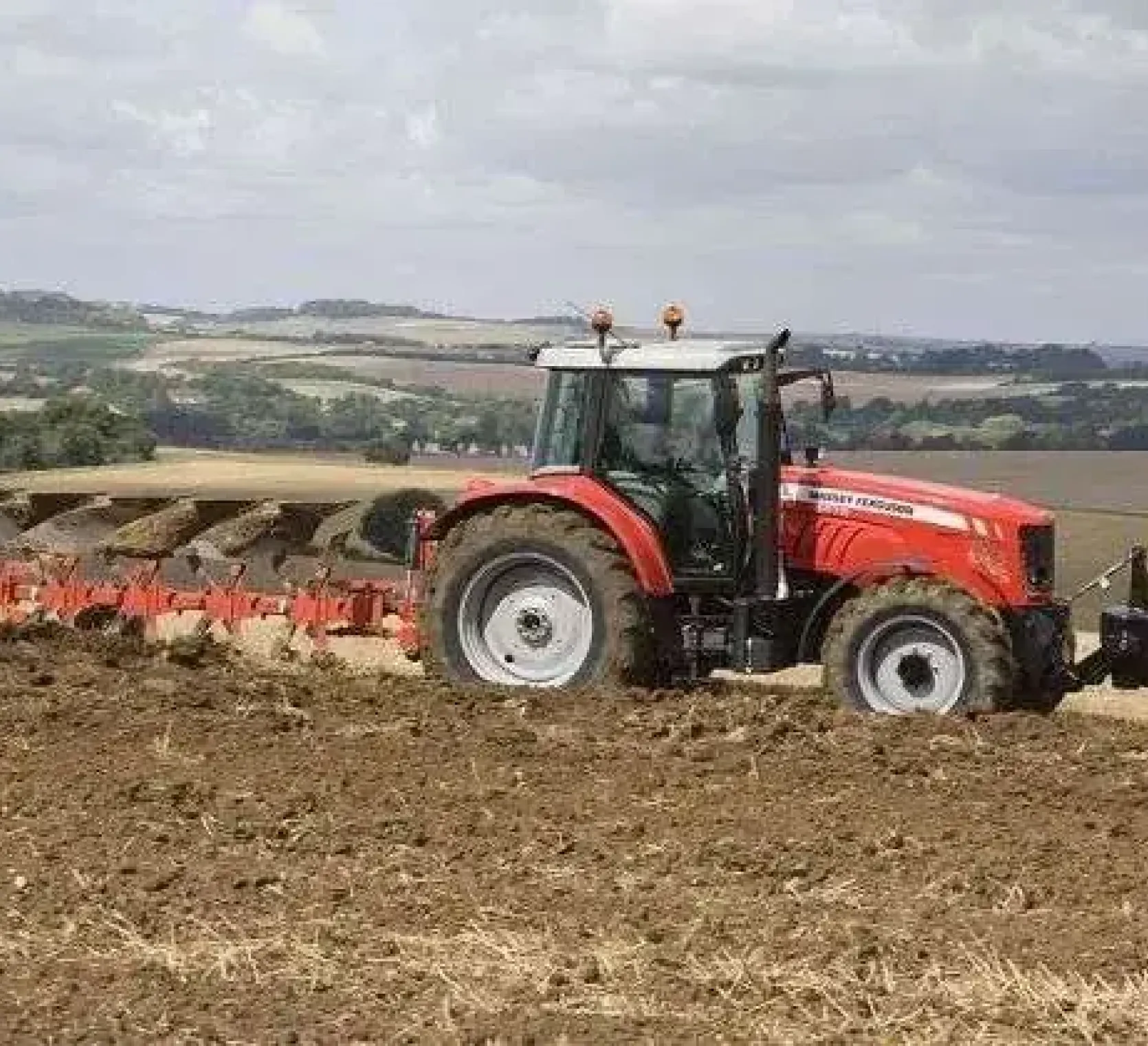Ciągnik rolniczy Massey Ferguson 5465 132 KM w pracy w polu z pługiem Gregoire Besson