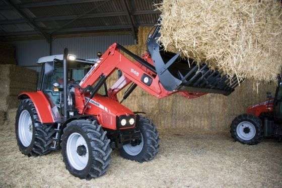 Ładowacz czołowy Ciągnik rolniczy Massey Ferguson 5455 112 KM podnosi siano u korbanka