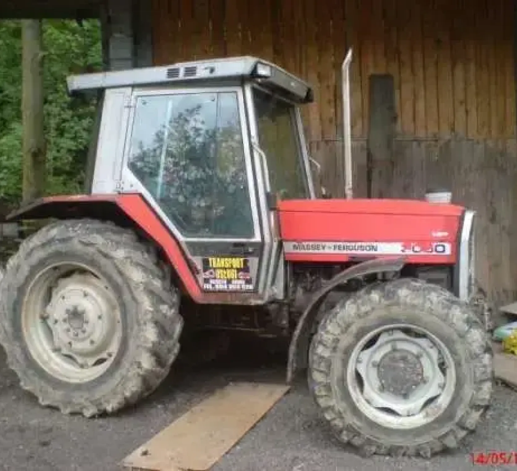 Czerwony używany ciągnik marki Massey Ferguson 3050 widok na bok 