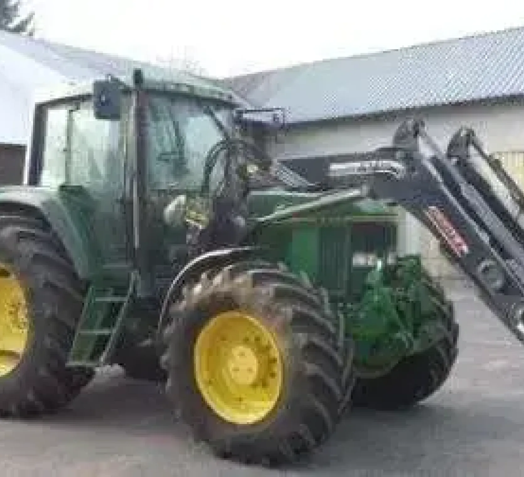 Widok z boku ciągnika uzywanego John Deere 6900, z ładowaczem.