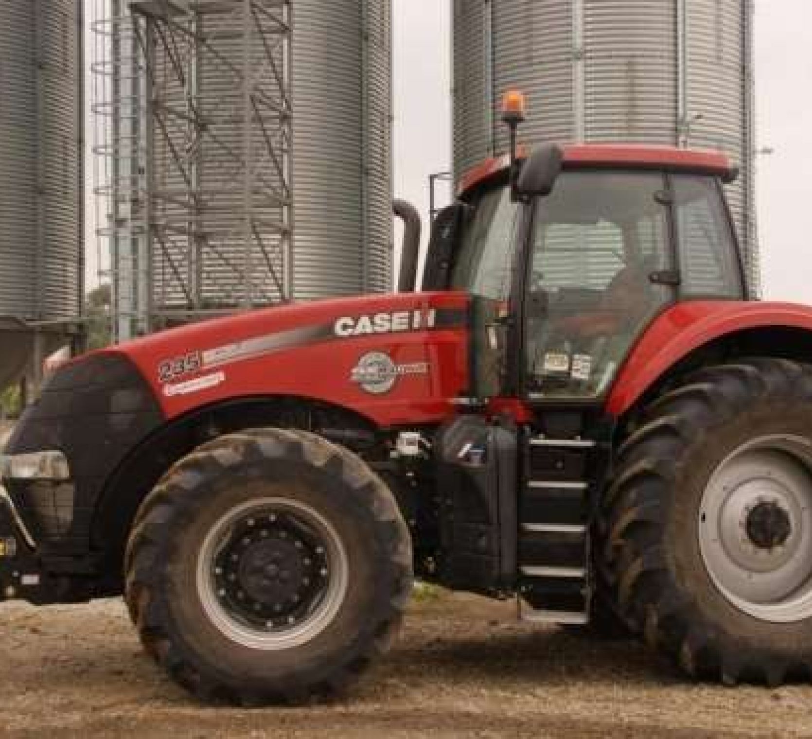Na tle silosów stoi ciagnik CASE IH Magnum 235
