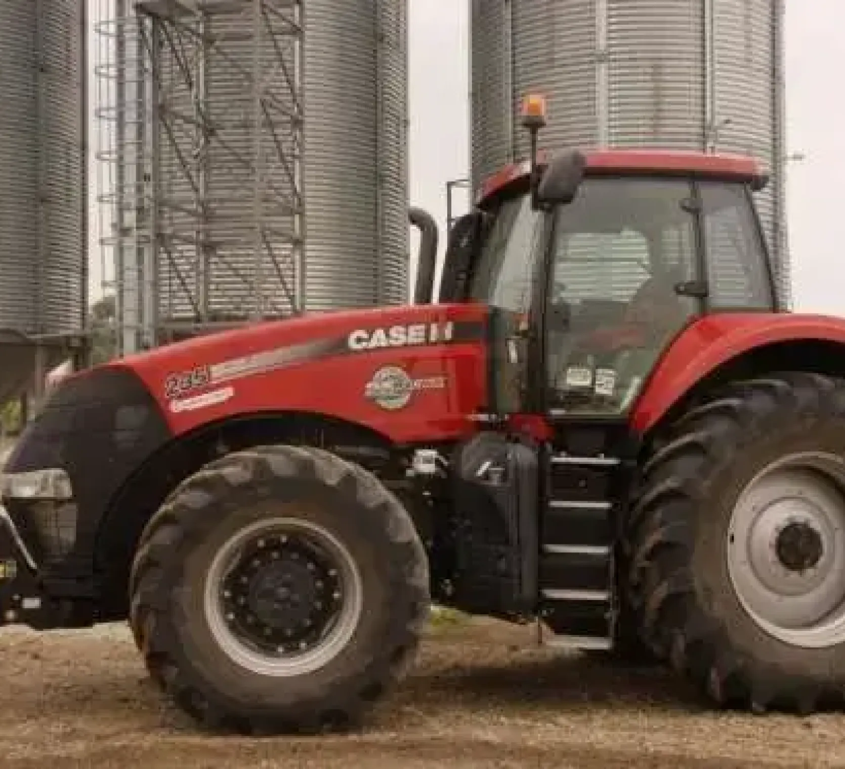 Na tle silosów stoi ciagnik CASE IH Magnum 235