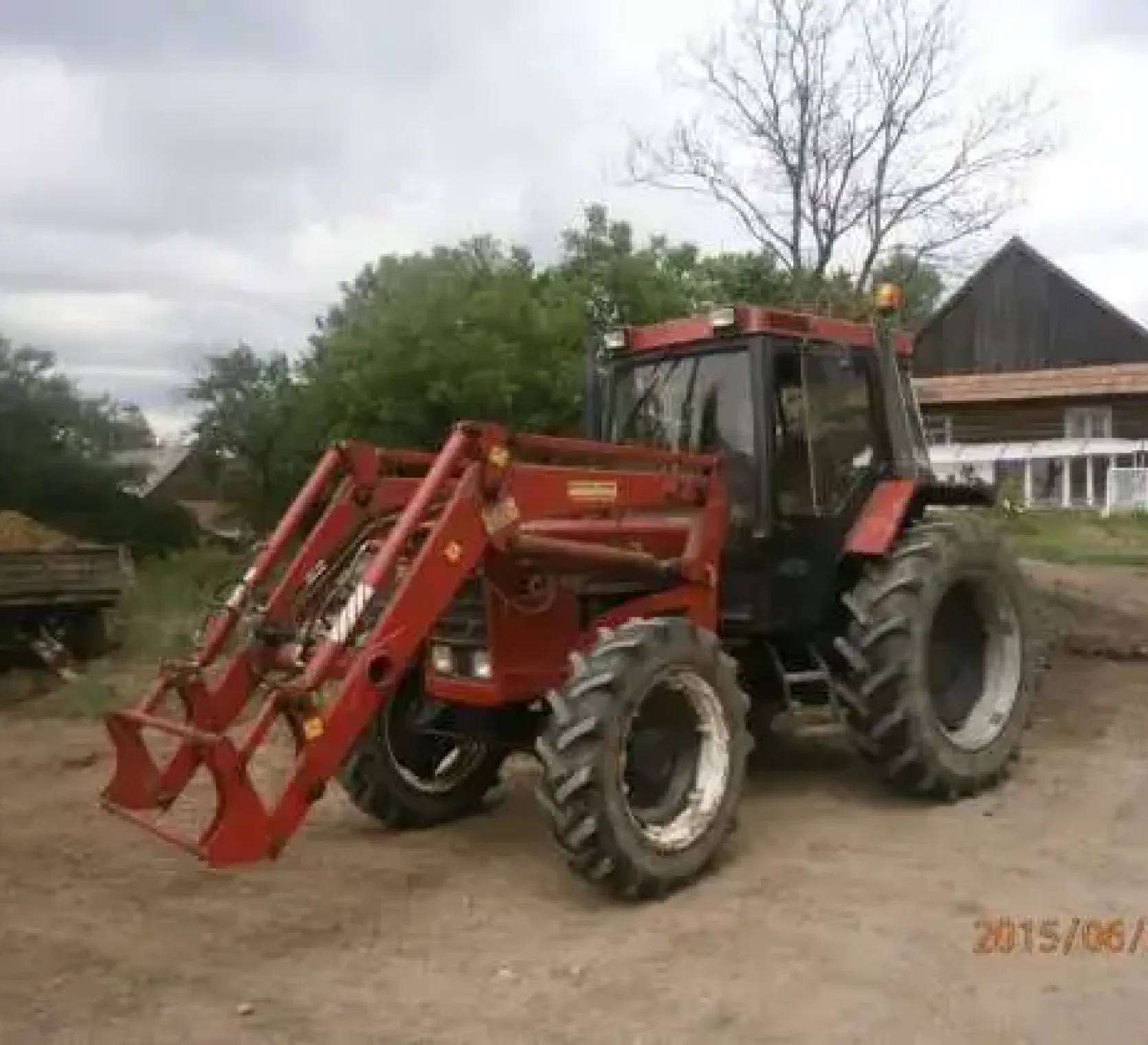 Na gospodarstwie stoi ciągnik CASE 856 z ładowaczem czołowym 