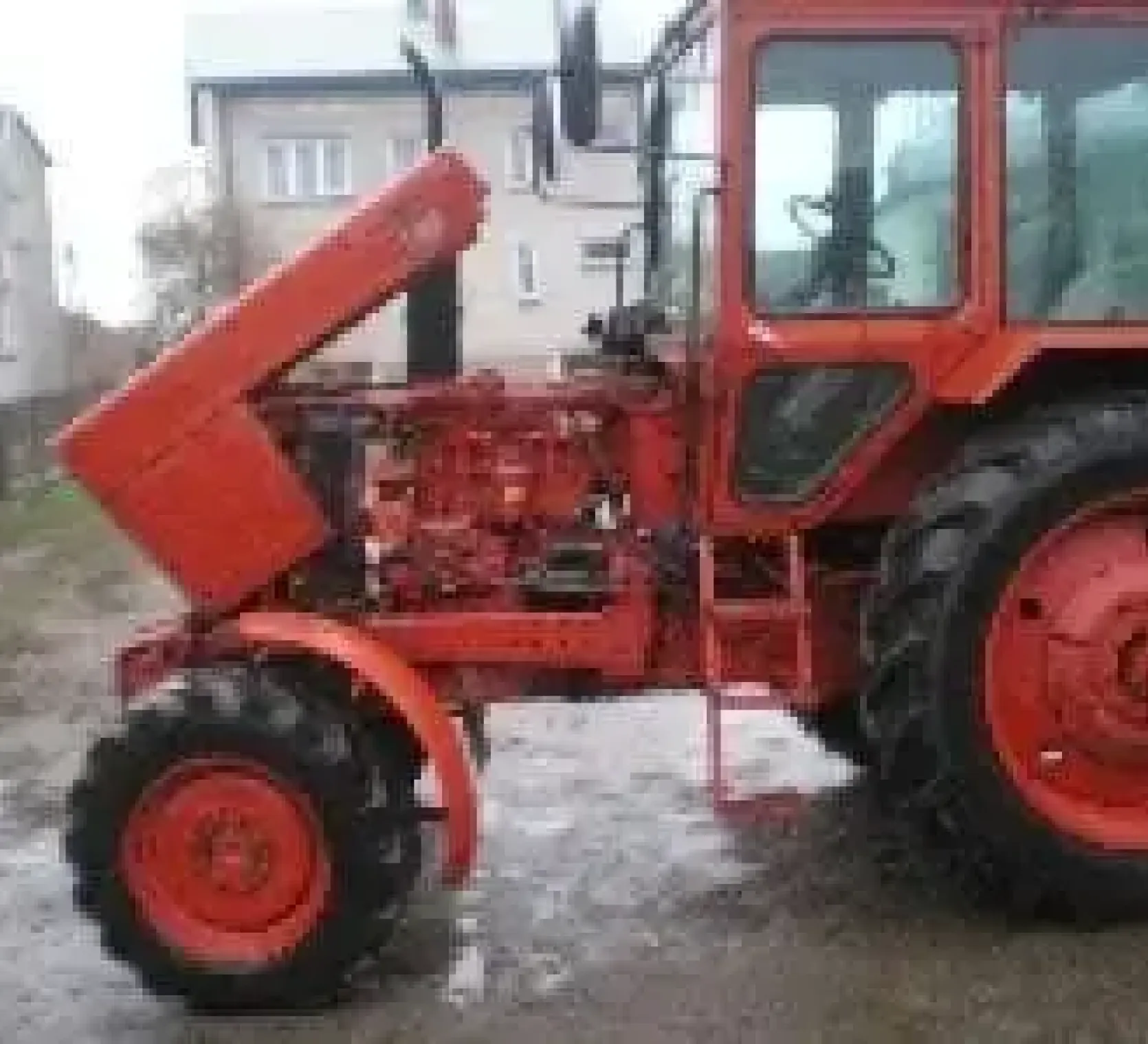 Widok na lewy bok używanego ciągnika rolniczego MTZ 82 KM z uniesioną maską 