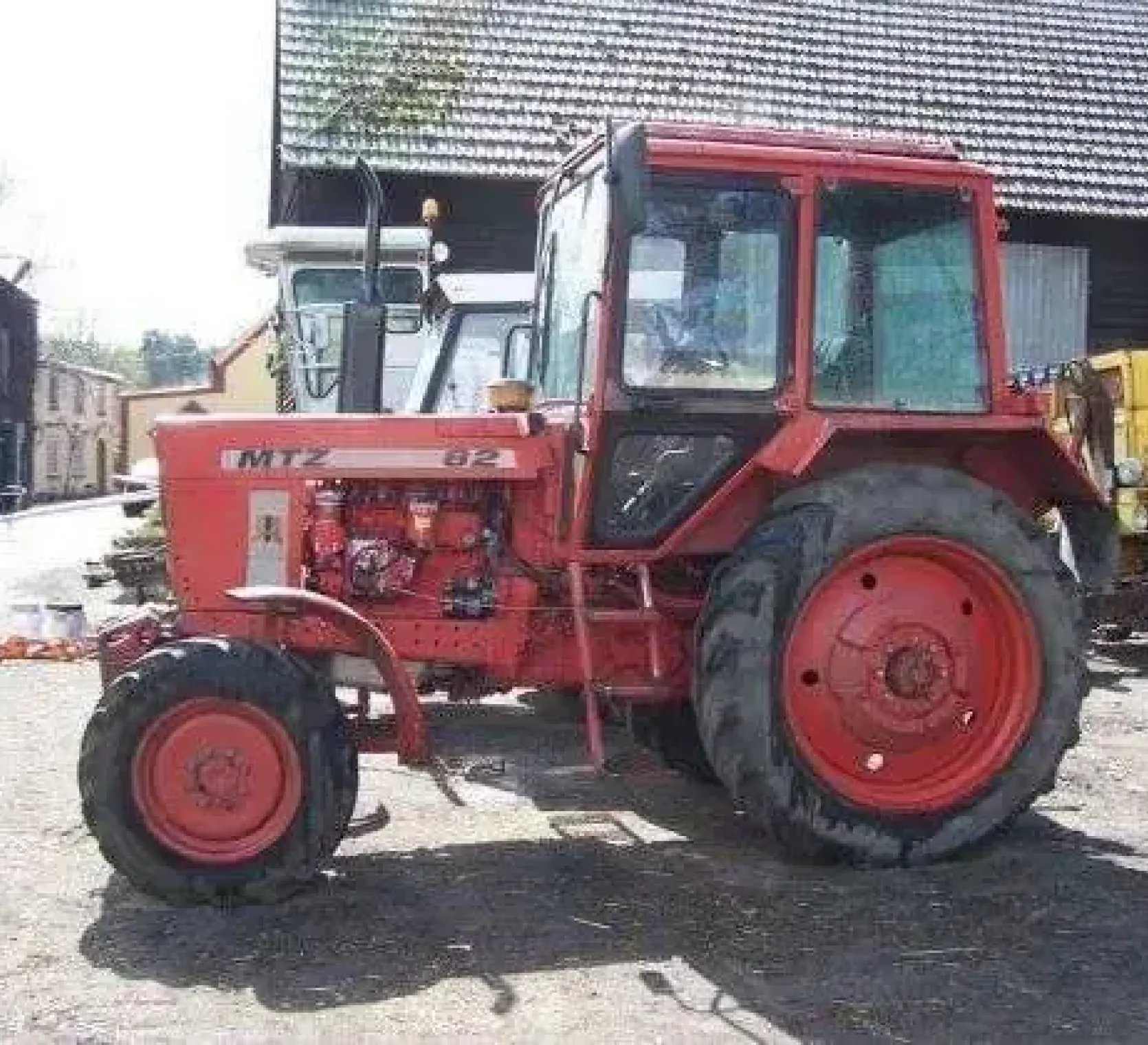 Bok używanego ciagnika rolniczego MTZ 82 w zabudowaniach gospodarstwa 