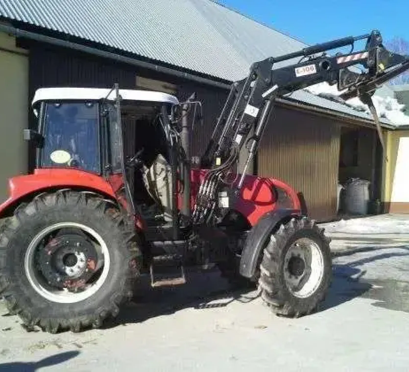 Ciągnik rolniczy Farmtrac wyposażony w ładowacz czołowy 