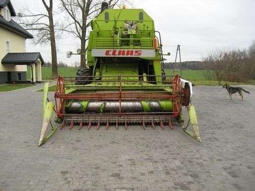 Używany Kombajn zbożowy Claas Mercator 75 z hederem  na utwardzonym placu widok z przodu