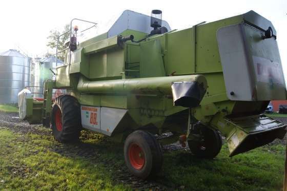 Używany Kombajn zbożowy Claas Dominator 88s zdjęcie z tylu w tle silos zbożowy