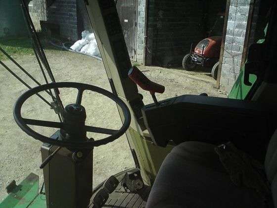Zdjęcie przedstawiające wnętrze kabiny kombajnu używanego John Deere 2056. 