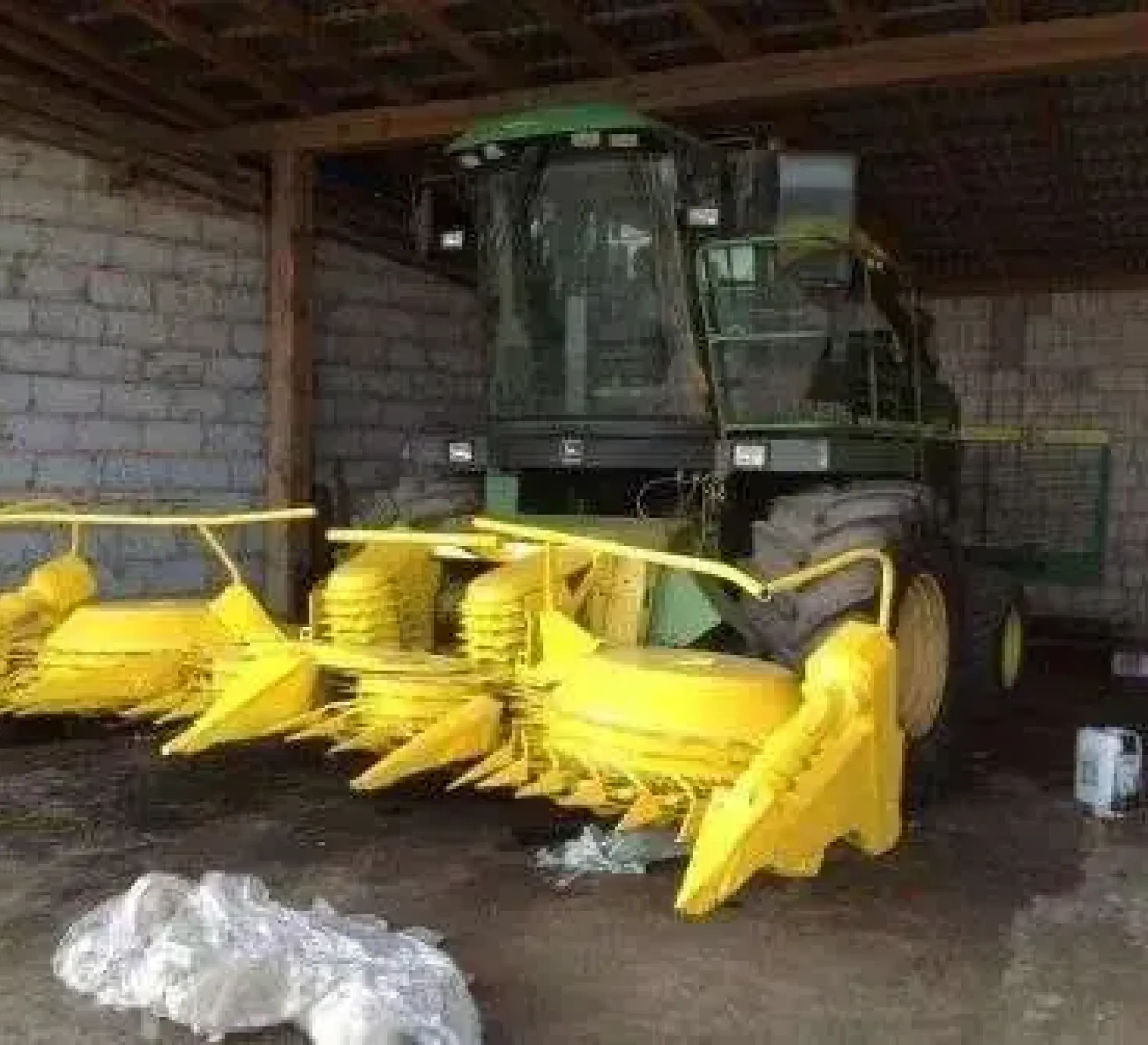 Widok z przodu sieczkarni używanej John Deere 5650, stojacej pod wiatą.