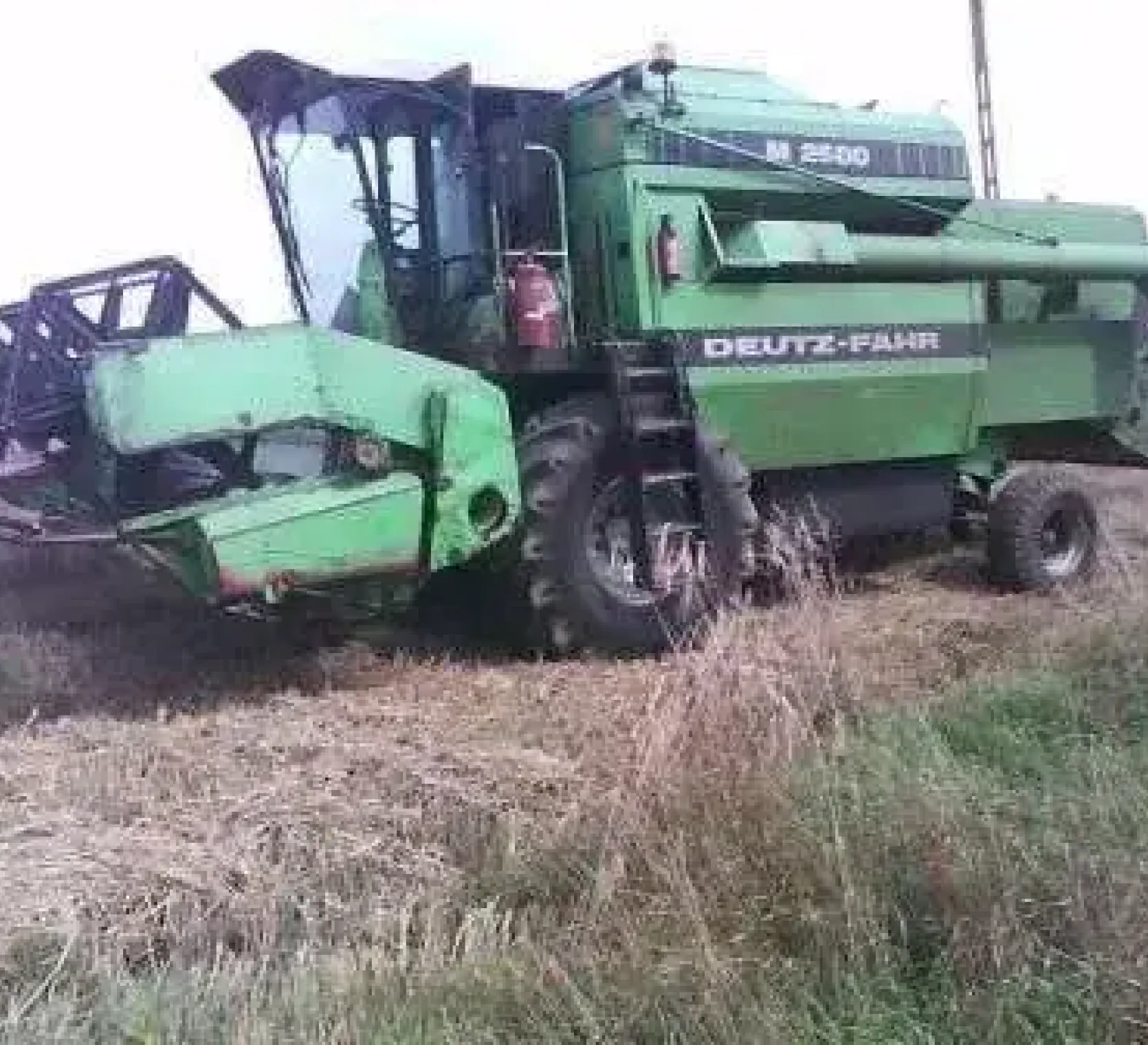Widok z boku kombajnu do zboża na polu Deutz-Fahr M 2580 używany rok produkcji 1986 korbanek.pl
