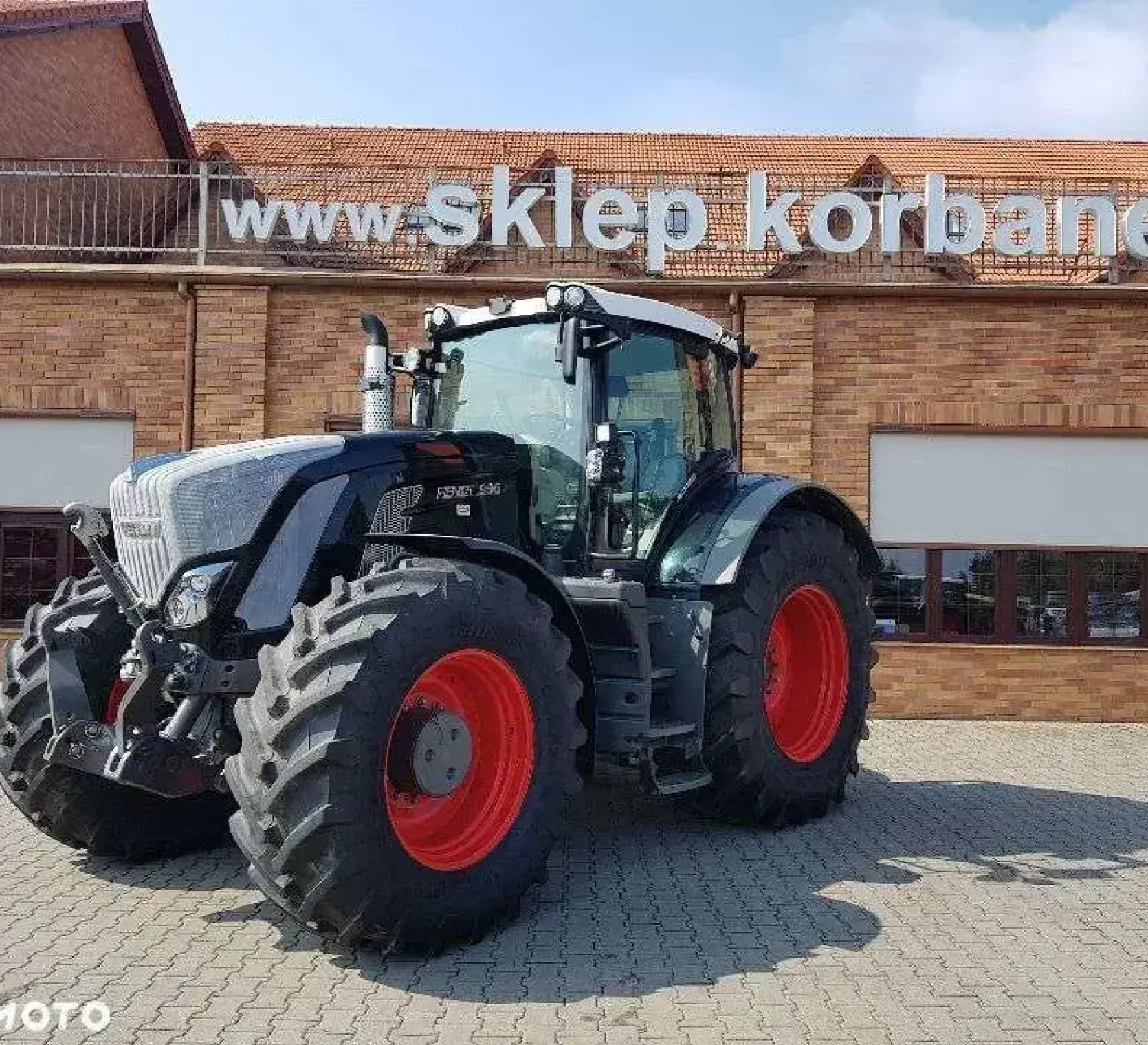 Czarny traktor Fendt 936 Vario na tle sklepu częsci widok z lewego boku