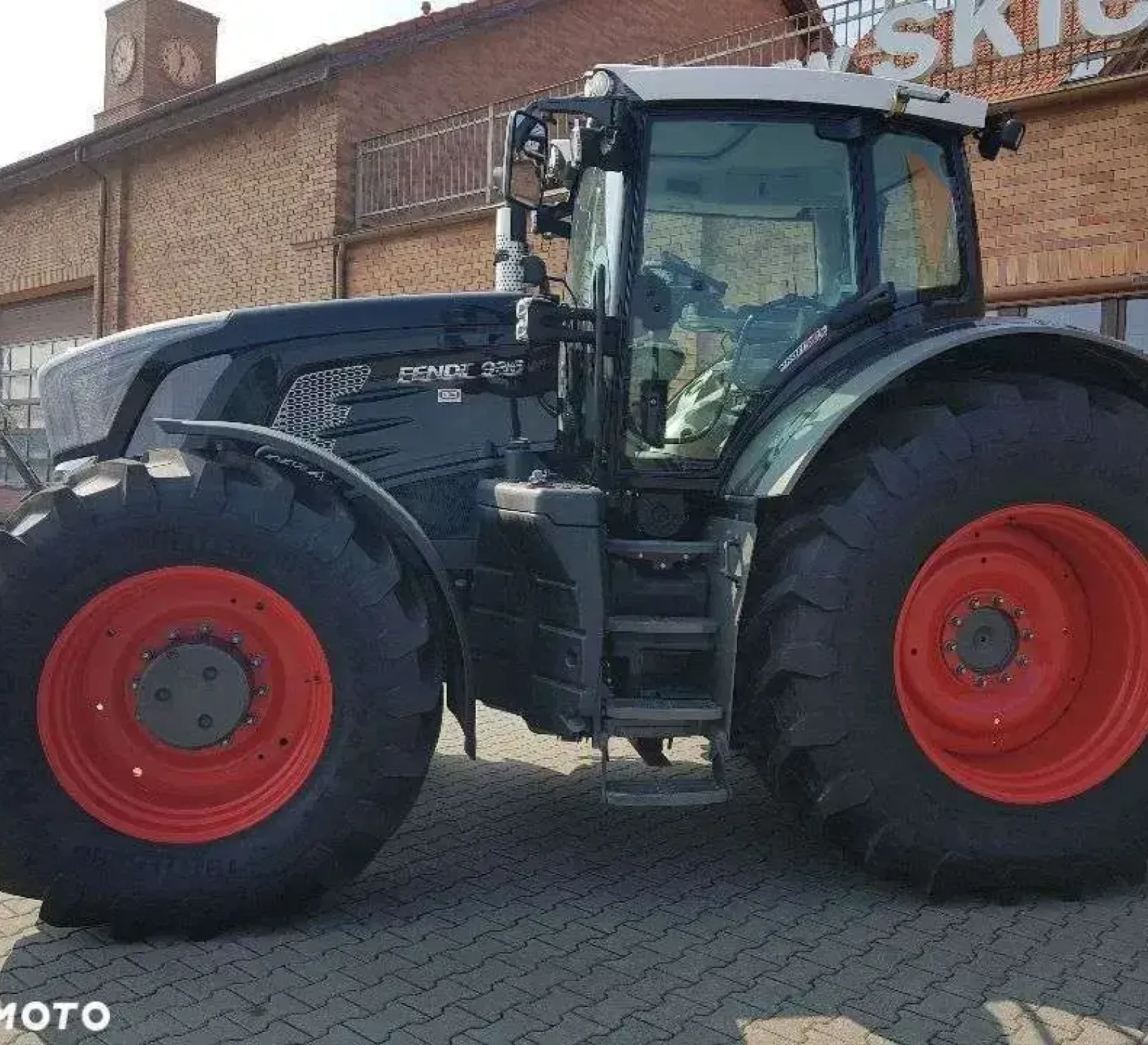 Czarny używany Fendt 936 widok z lewej strony na tle sklepu Korbanek