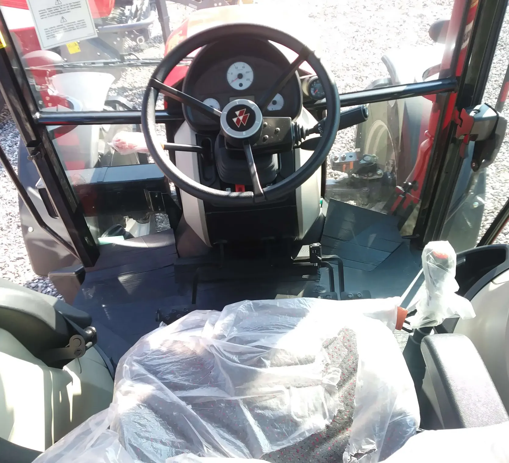 Wnętrze kabiny w ciągniku rolniczym Massey Ferguson 4707 widok na kierownicę