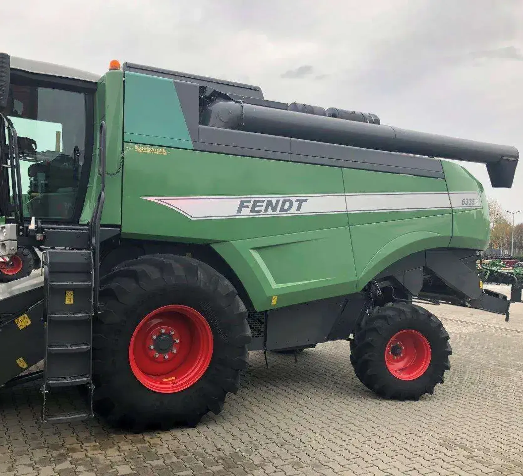 Heder do kombajnu Fendt 6335 C w tle drzewa i  hala widok z przodu
