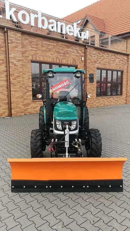 Ciągnik Arbos 2035 prezentowany od przodu z widokiem na spychacz Hydramet